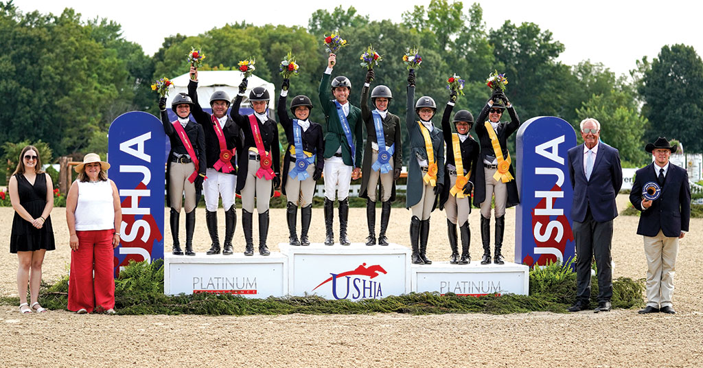Riders and supporters celebrating on the International Hunter Derby Team Competition podium